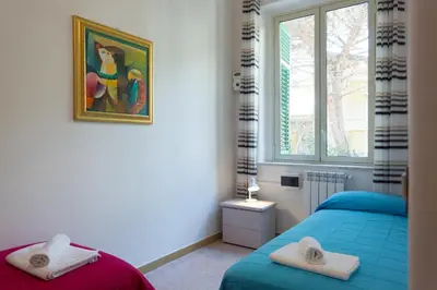 a bedroom with two beds and a painting on the wall at Mondello House Eraclea in Mondello