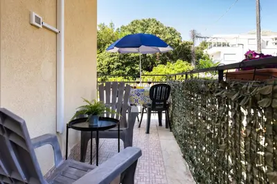 a patio with chairs and a table with an umbrella at Mondello House Eraclea in Mondello