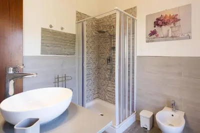 a bathroom with a shower and a white sink at Mondello House Eraclea in Mondello