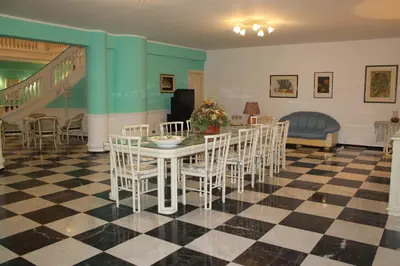 a dining room with a table and chairs on a checkered floor at Palazzo Scavone in Palermo