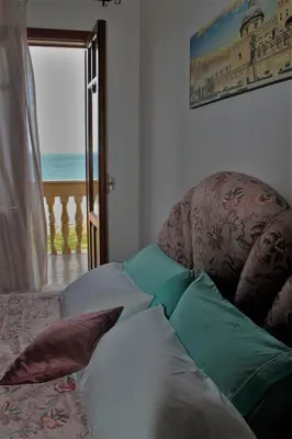 a room with pillows on a bed with a view of the ocean at Palazzo Scavone in Palermo