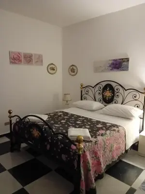 a bedroom with a bed with a black and white comforter at Palazzo Scavone in Palermo