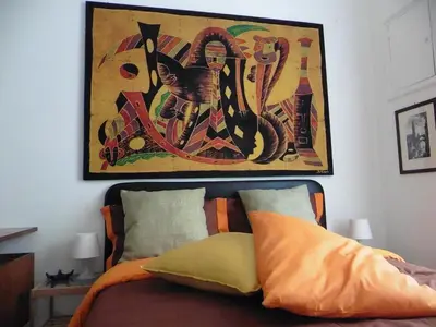 a bedroom with a bed with a painting on the wall at Bobnb in Palermo
