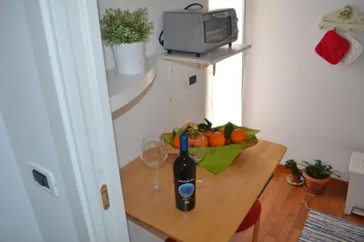 a table with a bottle of wine and a bowl of fruit at Appartamento Alla Zisa in Palermo