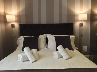 a white bed with three pillows on it at 29 Venti Luxury in Palermo