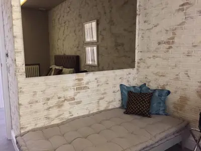 a mirror on a brick wall with a bench at 29 Venti Luxury in Palermo