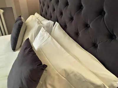 a bed with white sheets and pillows on it at 29 Venti Luxury in Palermo