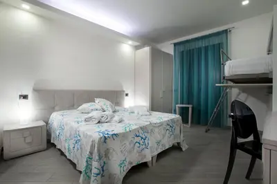 a bedroom with a bed with a blue and white blanket at Monte Monaco B&B in San Vito lo Capo