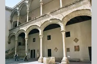 two people walking in a large building with columns at Piazza Marina Chic in Palermo