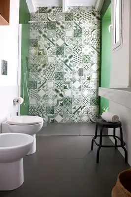 a bathroom with a white toilet and a green wall at Curù in Castellammare del Golfo