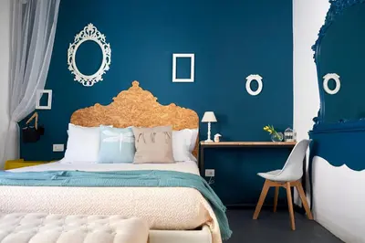 a blue bedroom with a bed and a chair at Curù in Castellammare del Golfo