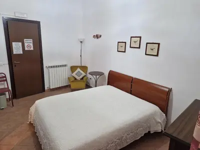 a bedroom with a bed and pictures on the wall at Nostra casa rooms in Palermo