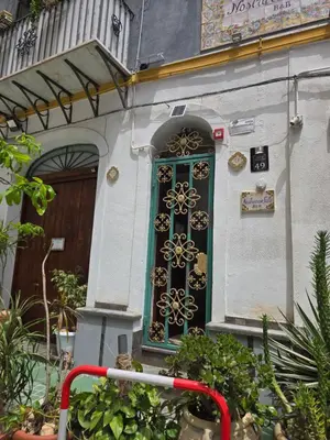 a green door with a flower design on a building at Nostra casa rooms in Palermo