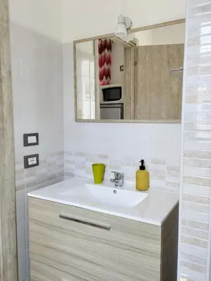 a bathroom with a sink and a mirror at Appartamenti Blu Mare in Castellammare del Golfo