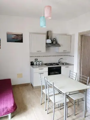 a kitchen with a table and chairs in a room at Appartamenti Blu Mare in Castellammare del Golfo