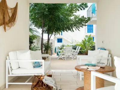 a patio with white furniture and a table at Lisca Bianca in San Vito lo Capo