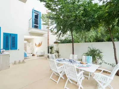 a patio with a table and chairs and a fence at Lisca Bianca in San Vito lo Capo