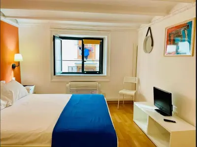 a bedroom with a bed and a desk with a television at Home Maletto in Palermo