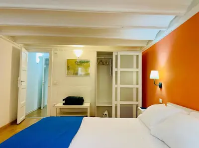a bedroom with a white bed and an orange wall at Home Maletto in Palermo