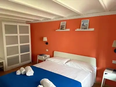 a bedroom with an orange wall with a bed at Home Maletto in Palermo