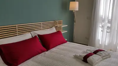 a bedroom with a bed with red and white pillows at B&B Casa Rosellina in Palermo