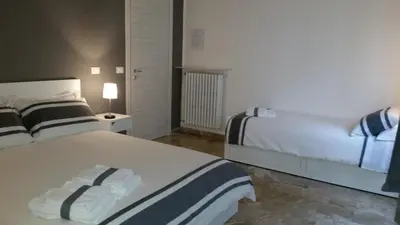 a bedroom with two beds and a night stand with at B&B Casa Rosellina in Palermo