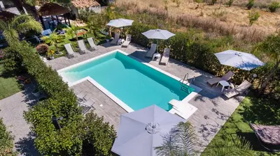 an overhead view of a swimming pool with umbrellas at Le Zagare in Lascari