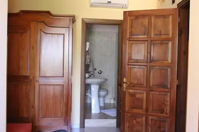 a bathroom with two wooden doors and a sink at Raggio di Sole Bed & Breakfast in Macari