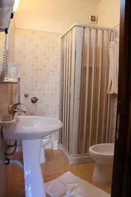 a bathroom with a shower and a sink and a toilet at Raggio di Sole Bed & Breakfast in Macari