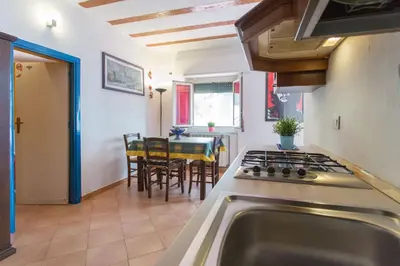 a kitchen with a stove top oven next to a table at Villa Mondello in Mondello
