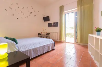 a bedroom with a bed and a table and a window at Villa Mondello in Mondello