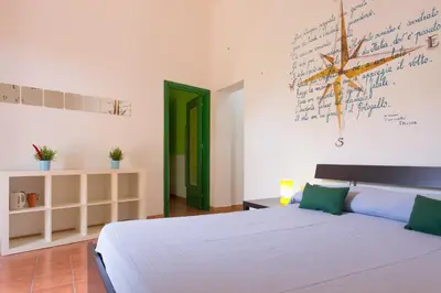 a bedroom with a white bed and a green door at Villa Mondello in Mondello
