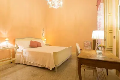 a bedroom with a bed and a table and a desk at B&B Porta Carolina in Palermo