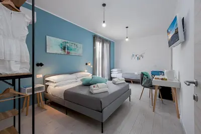 a bedroom with a bed and a blue wall at Samira in San Vito lo Capo