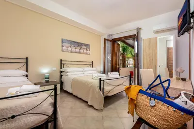 a bedroom with two beds and a table and a television at Samira in San Vito lo Capo