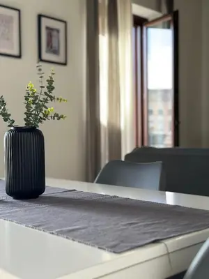 a black vase with flowers sitting on a table at Le Quattro Chiavi in Palermo