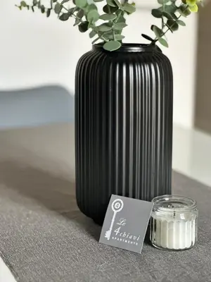 a black vase sitting on a table with a candle at Le Quattro Chiavi in Palermo