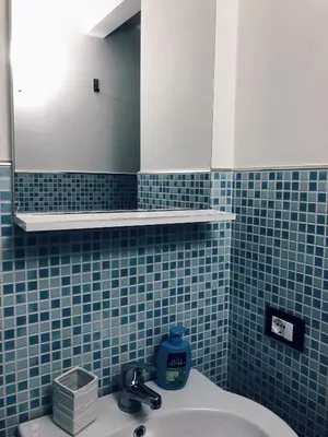 a blue tiled bathroom with a sink and a mirror at Le Quattro Chiavi in Palermo