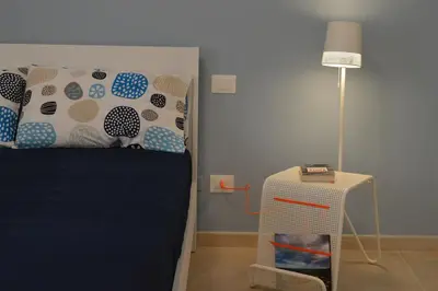 a bedroom with a bed and a floor lamp at Le Gemme di Sicilia Apartments in Castellammare del Golfo