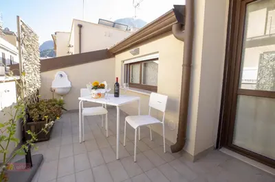 a small white table and chairs on a balcony at Le Gemme di Sicilia Apartments in Castellammare del Golfo