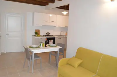 a kitchen and a living room with a table and a couch at Le Gemme di Sicilia Apartments in Castellammare del Golfo