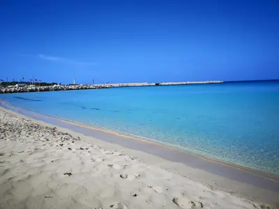 a beach with the ocean and a blue sky at Hawaii Siciliane in Castelluzzo
