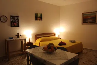 a hotel room with a bed and a table with a bowl of fruit at Appartamenti Via Marconi in Castellammare del Golfo