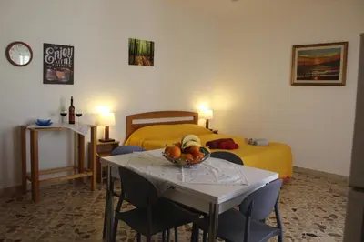 a room with a bed and a table with a bowl of fruit at Appartamenti Via Marconi in Castellammare del Golfo