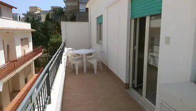 a balcony with a table and chairs on a building at Appartamenti Via Marconi in Castellammare del Golfo