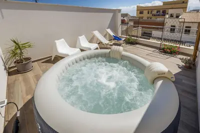 a hot tub on top of a balcony with chairs at La Suite Di Tyche in Castellammare del Golfo