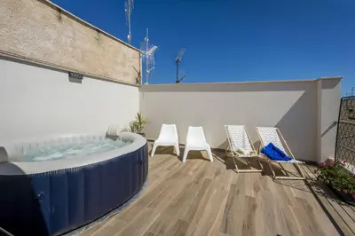 a patio with chairs and a hot tub on a building at La Suite Di Tyche in Castellammare del Golfo