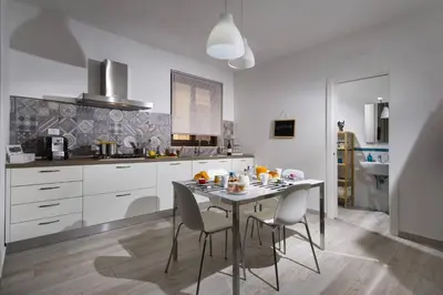 a kitchen with a table and chairs in it at La Suite Di Tyche in Castellammare del Golfo