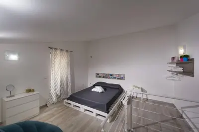 a bedroom with a bed in a white room at La Suite Di Tyche in Castellammare del Golfo