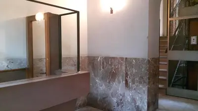 a bathroom with a mirror and a stone wall at Profumo di Sicilia in Palermo